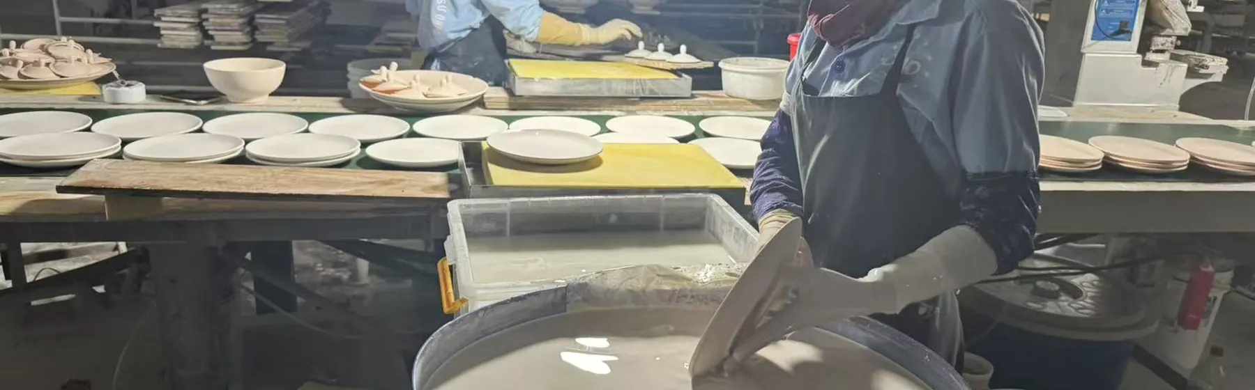 Hand dip-glazing a stoneware plate