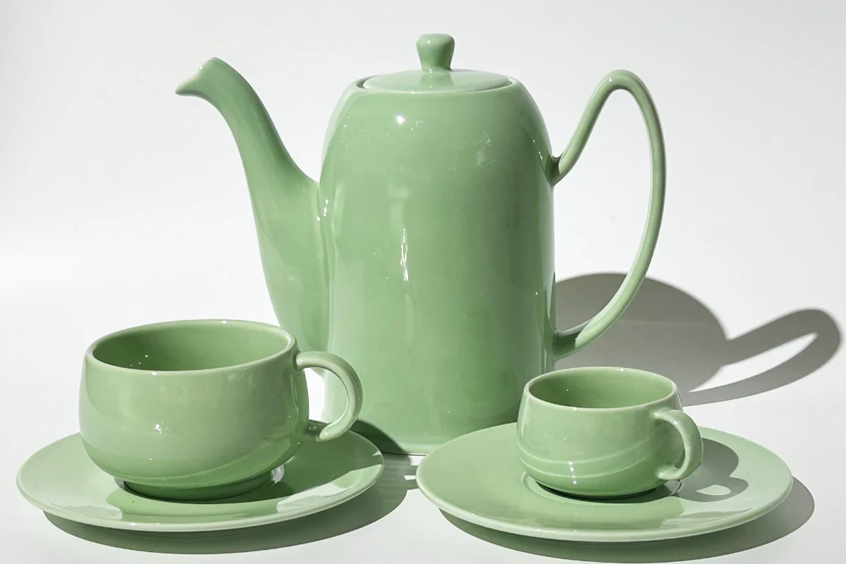 Sage-green glazed ceramic teapot with cups and saucers