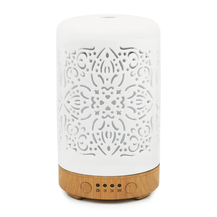 White pierced ceramic ultrasonic diffuser on a wood-grain base