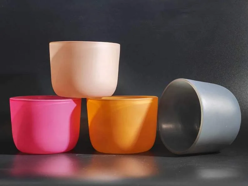 Spray-colored glass candle vessels in pink, orange, blush and grey