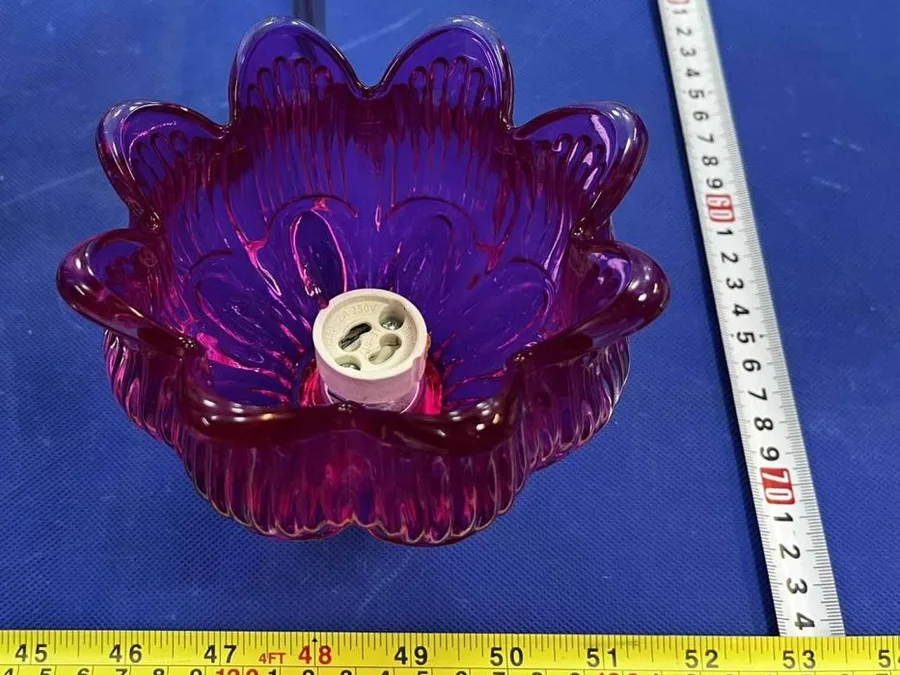 A glass candle holder measured against a tape during inspection