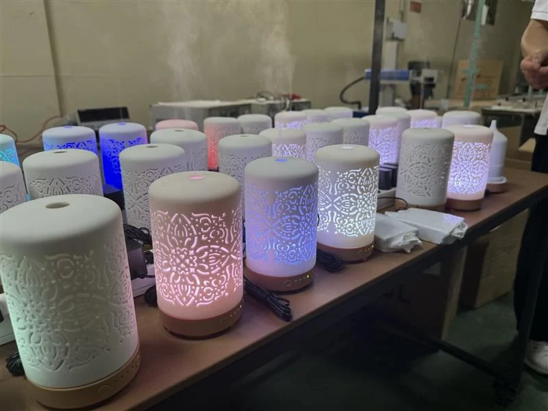 Finished pierced ceramic diffusers lit and misting on a bench in Vietnam