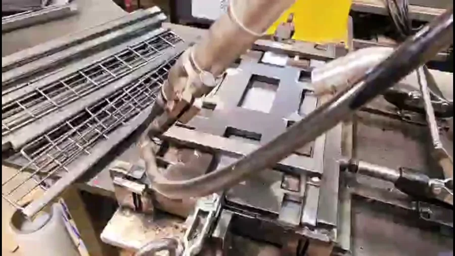 Robotic welding torch over a wire rack on a jig